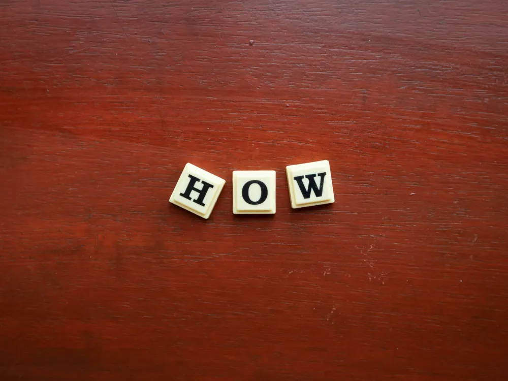 Scrabble letters H, O, W placed to read "How".