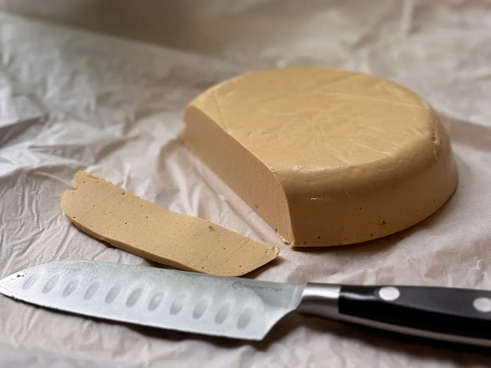 Plant-based cashew cheece with a knife on the side.