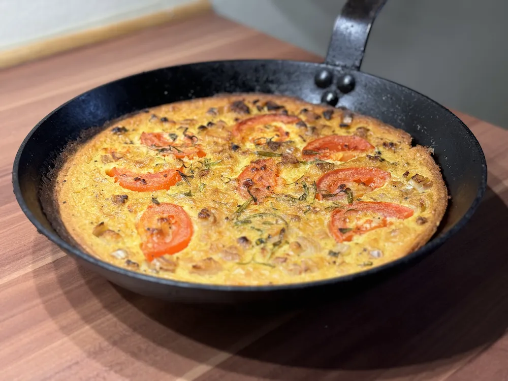 Farinata, an Italian chickpea flour pancake, still in the frying pan.